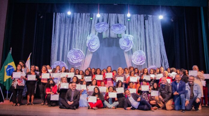 Mulheres fazem festa no teatro ao receber certificado profissional